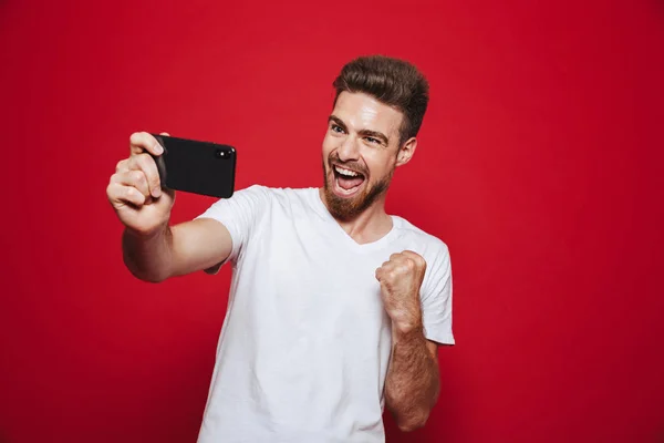 Retrato Joven Barbudo Feliz Mirando Teléfono Móvil Celebrando Aislado Sobre — Foto de Stock