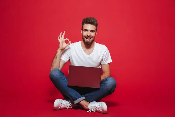 Porträtt Lycklig Ung Skäggig Man Visar Medan Sittande Med Bärbar — Stockfoto