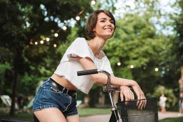 公園で自転車に座っている夏服の少女 — ストック写真