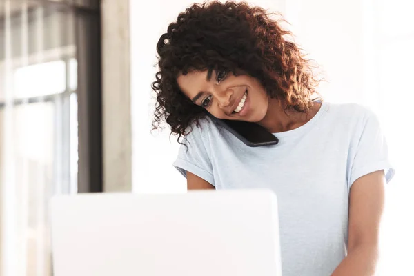 Mujer Africana Feliz Hablando Teléfono Móvil Mientras Que Uso Ordenador — Foto de Stock