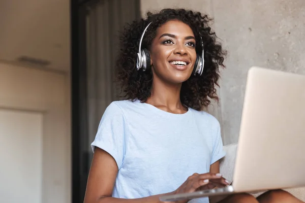 Glückliche Afrikanerin Mit Kopfhörer Und Laptop Während Sie Hause Auf — Stockfoto