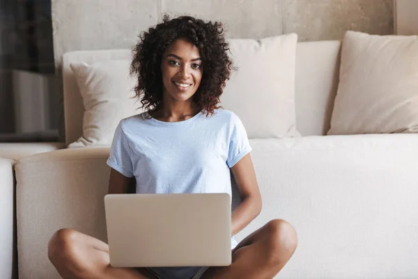 Vrolijke Afrikaanse Vrouw Met Behulp Van Laptopcomputer Zittend Een Bank — Stockfoto