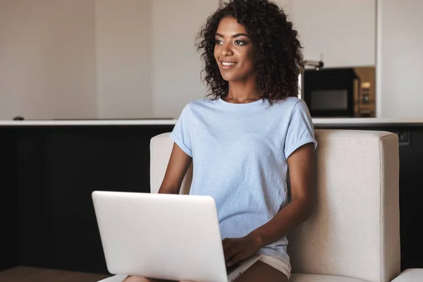 Mulher Africana Feliz Usando Computador Portátil Enquanto Sentado Sofá Casa — Fotografia de Stock