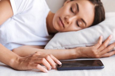 Blnk cep telefonu sceen parmağına ile evde kanepede uyuyan genç ve güzel Asyalı kadın