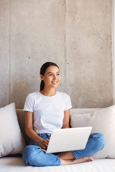 Lächelnde Junge Asiatin Mit Laptop Computer Während Sie Hause Auf — Stockfoto