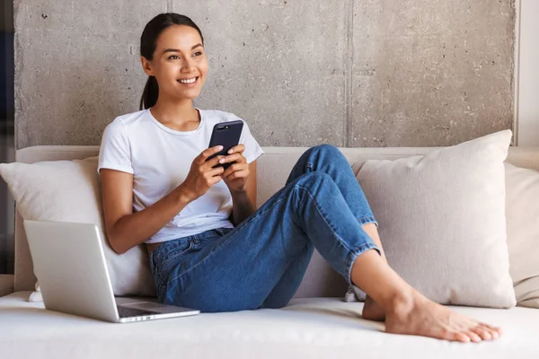 Feliz Jovem Mulher Asiática Usando Telefone Celular Enquanto Sentado Sofá — Fotografia de Stock