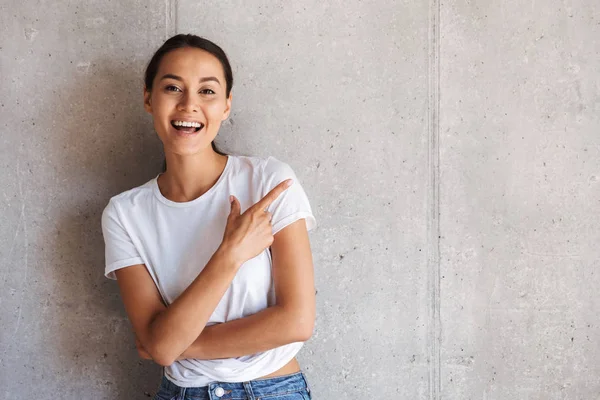 Sonriente Joven Asiático Mujer Apuntando Lejos Copia Espacio Sobre Gris —  Fotos de Stock