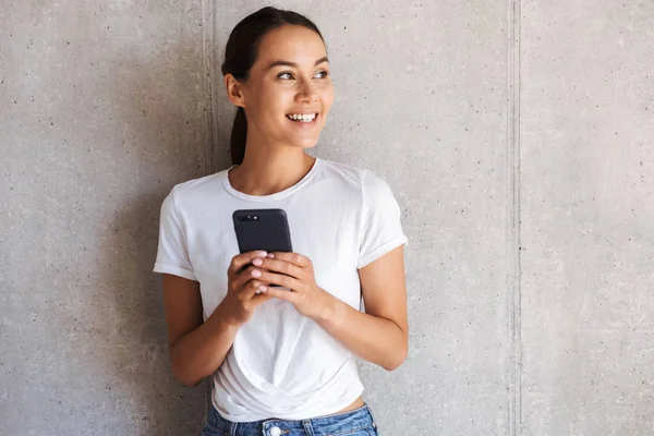 Sorrindo Jovem Mulher Asiática Usando Telefone Celular Olhando Para Espaço — Fotografia de Stock