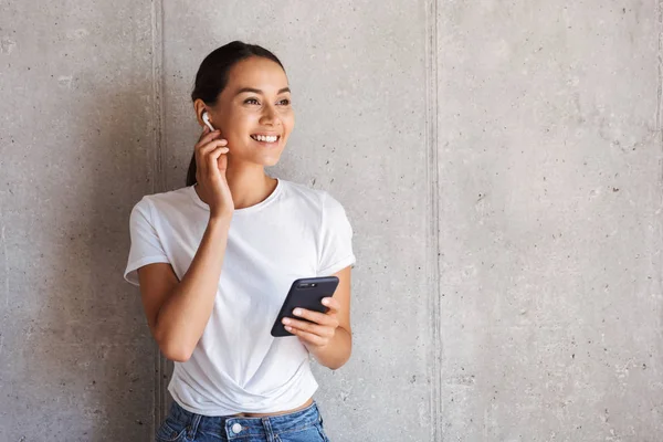 Sorrindo Jovem Mulher Asiática Fones Ouvido Usando Telefone Celular Olhando — Fotografia de Stock