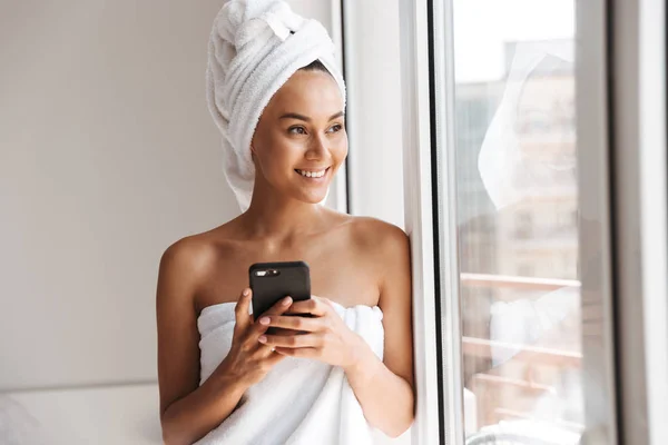 Sorridente Giovane Donna Asiatica Avvolto Asciugamano Doccia Utilizzando Telefono Cellulare — Foto Stock