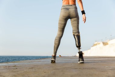 Arkadan görünüm olan Protez bacak ayakta plajda Engelli sporcu kadın kapatmak