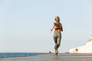 Protez bacakla plajda açık çalışan genç engelli kadın görünümünü geri