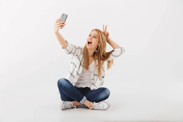 Portret Wesoły Młodych Dorywczo Dziewczynka Biorąc Selfie Telefon Komórkowy Siedząc — Zdjęcie stockowe