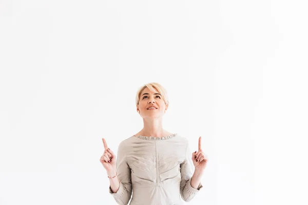 笑みを浮かべて ポイントは 代指上方 Copyspace Studio で白い背景に分離でかなり成熟した金髪の女性のイメージ — ストック写真