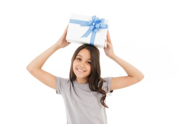 Sürpriz hediye kutusu tutarak kamera seyir beyaz duvar arka plan üzerinde izole mutlu kız ayakta fotoğrafı.