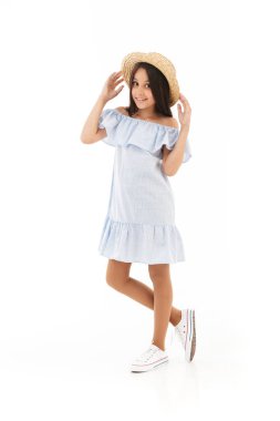 Tam boy görüntü memnun genç esmer kız elbise ve beyaz arka plan üzerinde kameraya bakarken poz hasır şapka