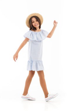 Şirin kız yürüyüş beyaz duvar arka plan üzerinde izole görüntüsü. Görünümlü kamera.