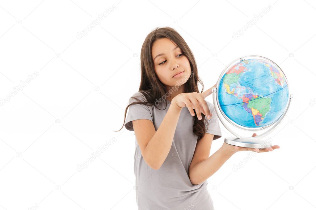 Photo of cute girl standing isolated over white wall background holding globe.