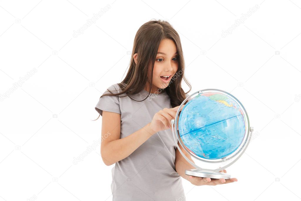 Photo of cute girl standing isolated over white wall background holding globe.