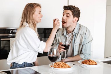 Mutfakta genç sevgi dolu çift fotoğraf var spagetti yemek bir yemek içme şarap.