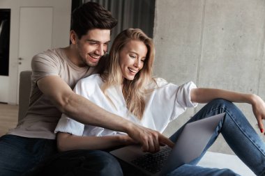 Şaşırmış mutlu sevgi dolu çift kapalı dizüstü bilgisayar kullanan kanepe üzerinde ev fotoğraf genç heyecanlı.