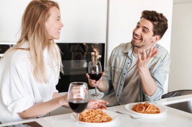 Mutfakta genç sevgi dolu çift fotoğraf var spagetti yemek bir yemek içme şarap.