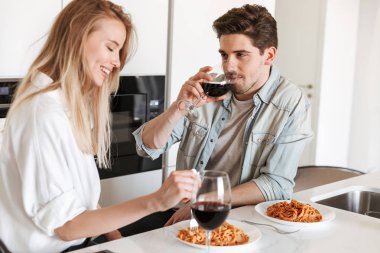 Mutfakta genç sevgi dolu çift fotoğraf var spagetti yemek bir yemek içme şarap.