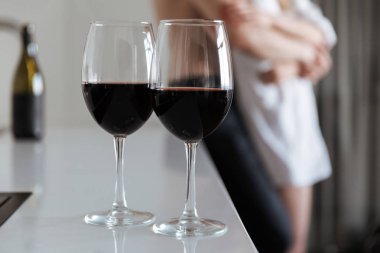 İki kadeh kırmızı şarap ile seven çift arka plan üzerinde kapalı ev genç ile görüntü.