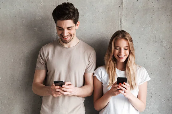 Foto Personas Positivas Hombre Mujer Sonriendo Mientras Ambos Utilizan Teléfonos — Foto de Stock