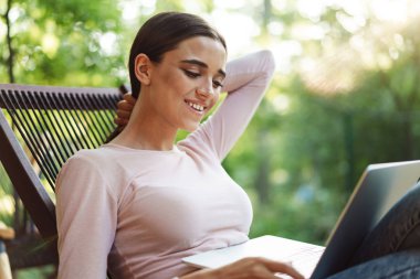 Dizüstü bilgisayar kapalı bir kafede oturuyor gülümseyen genç kız