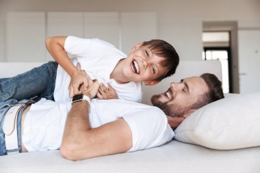 Mutlu bir genç baba ve oğlu eğleniyor portre evde vakit