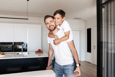 Mutlu yakışıklı oğlu 8-10 modern stüdyo dairede oturan piggybacking fotoğrafı