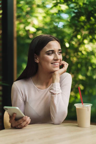 Sonriente Joven Sosteniendo Teléfono Móvil Mientras Está Sentado Café Aire — Foto de Stock