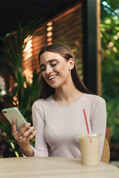 Chica Joven Feliz Usando Teléfono Móvil Mientras Está Sentado Café — Foto de Stock
