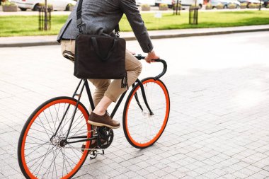 Şehrin sokak bir bisiklet sürme bir çanta ile genç işadamı resim kırpılmış
