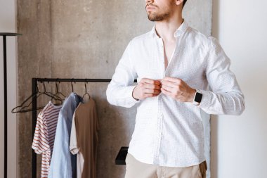 Bir adamın beyaz gömlekli, yatak dururken kadar düğmelerini kırpılmış görüntü