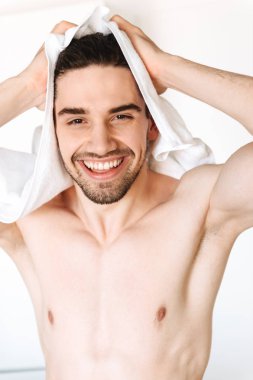 Mutlu genç çıplak adam duştan sonra bir havlu ile onun saç kurutma