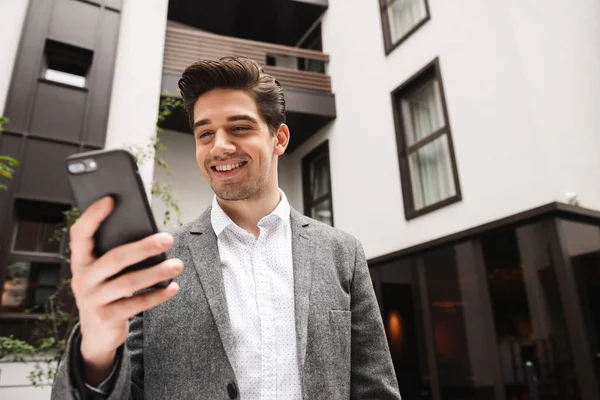 Smiling Young Businessman Using Moible Phone While Standing Outdoors — Stock Photo, Image