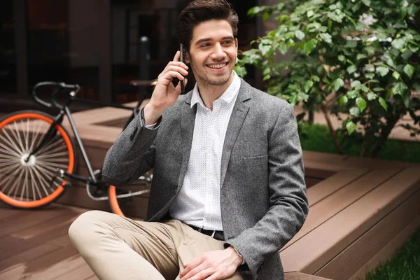 Smiling Young Businessman Talking Moible Phone While Sitting Outdoors — Stock Photo, Image