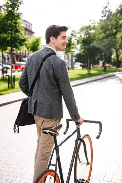 Visão Traseira Jovem Empresário Sorridente Andando Com Uma Bicicleta Rua — Fotografia de Stock