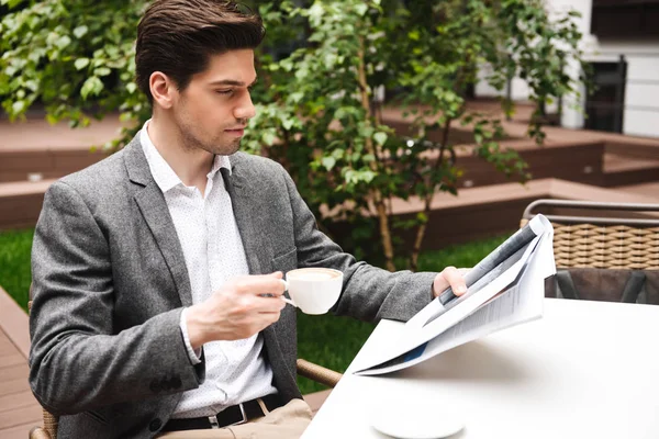 Selbstbewusster Junger Geschäftsmann Anzug Trinkt Kaffee Während Draußen Café Zeitung — Stockfoto
