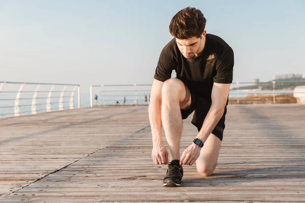 Image Concentrated Young Sportsman Standing Outdoors Beach Tie His Laces — Stock Photo, Image