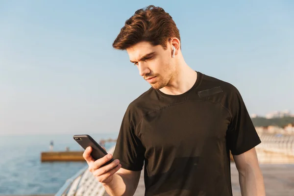 Foto Jovem Desportista Concentrado Livre Praia Ouvindo Música Com Fones — Fotografia de Stock