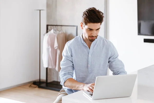 Hombre Joven Serio Camisa Usando Computadora Portátil Mientras Está Sentado — Foto de Stock