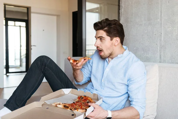 Excited Young Man Holding Remote While Sitting Couch Home Eating — Stock Photo, Image