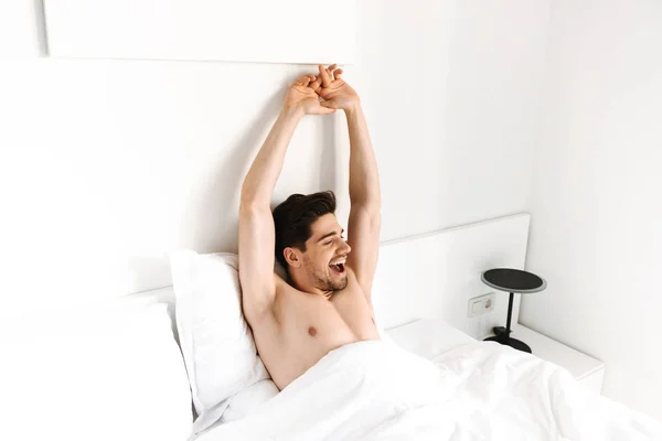 Feliz Homem Sem Camisa Esticando Mãos Enquanto Deitado Cama Casa — Fotografia de Stock