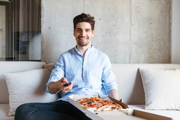 Happy Young Man Holding Remote Control While Sitting Couch Home — Stock Photo, Image