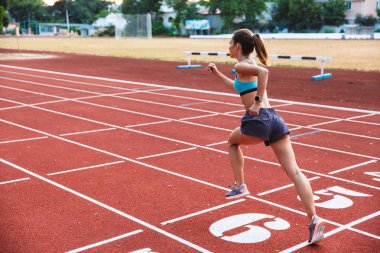 Arkadan bir mesafe stadyumda çalıştıran uygun bir sporcumuz görünüşü