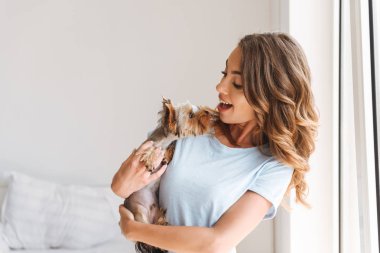 Mutlu genç kadın evde köpekle oynamayı