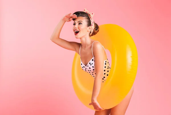 ゴージャスな若いピンナップ女性インフレータブル リングと水着でピンクの背景壁を越えて分離の写真 よそ見 — ストック写真